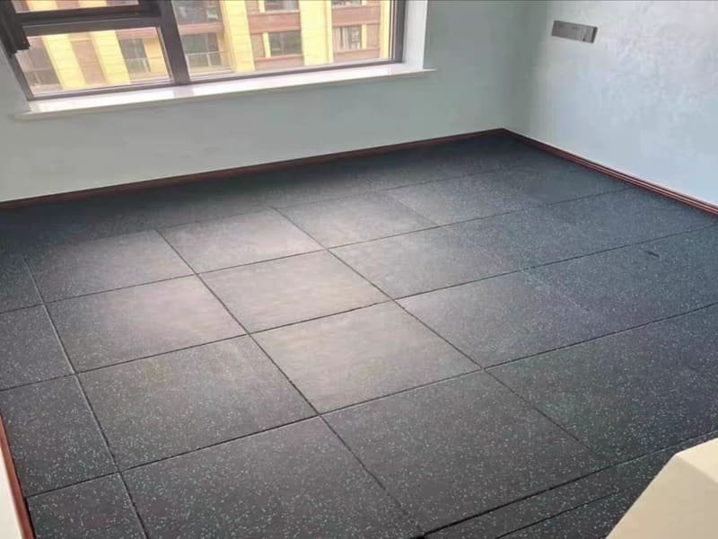 A professional flooring installer using a trowel to apply adhesive to a subfloor.
